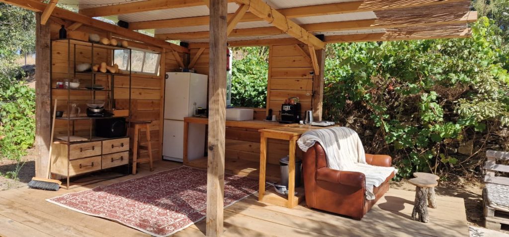 Cozinha exterior moderna para churrasco e área de convívio em madeira.